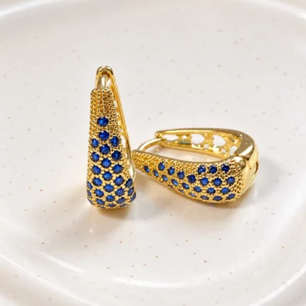 aros huggie de oro con piedras azul zafiro, joyería de lujo cotidiano en Chile.
