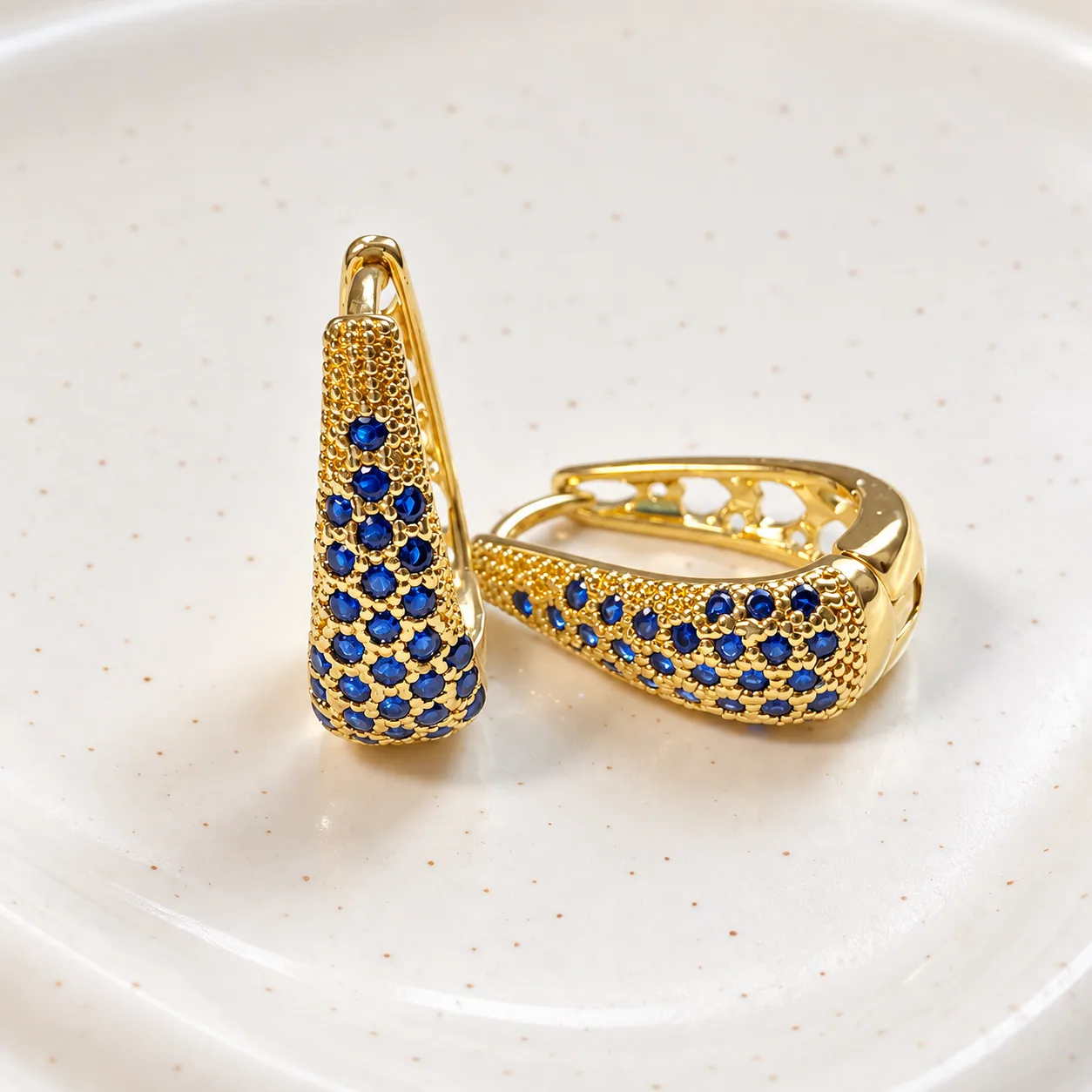 Aros Astra aros huggie de oro con piedras azul zafiro, joyería de lujo cotidiano en Chile.